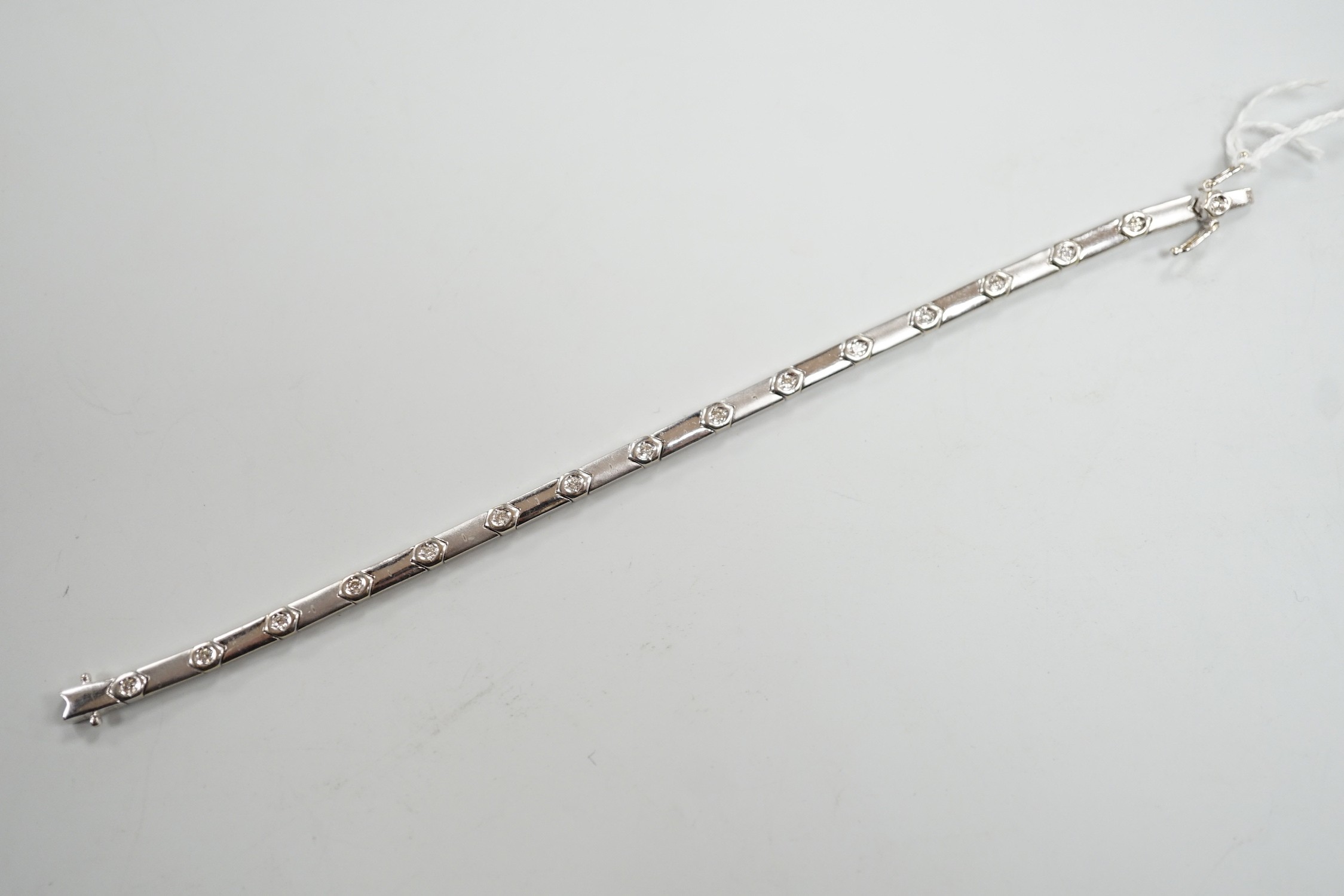 A modern 18k white metal and diamond chip set line bracelet, 15cm, gross weight 10.4 grams.